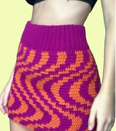 a close up of a person wearing a skirt with an orange and pink pattern on it