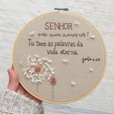 a person holding up a cross - stitch hoop with the words, senior and dandelions on it