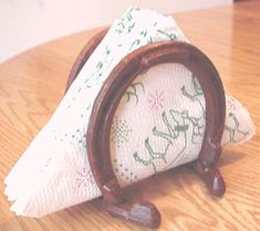 a napkin holder with a wooden handle on top of a table