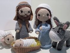 crocheted nativity scene with baby jesus and three donkeys in front of them