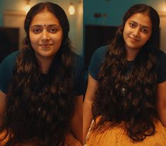 a woman with long dark hair sitting in front of a mirror looking at the camera