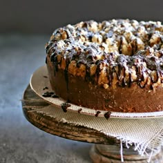 a cake with chocolate icing and nuts on top is sitting on a platter