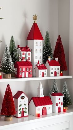 a shelf filled with christmas decorations on top of white shelves covered in red and white houses