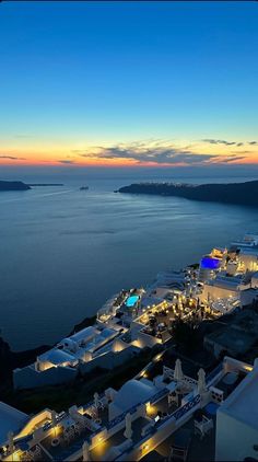 an aerial view of the ocean and buildings at night with bright lights on it's sides