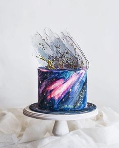 a blue and purple cake with gold sprinkles