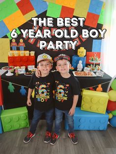 two young boys standing next to each other in front of a table with legos on it