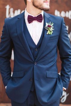 a man in a blue suit and bow tie