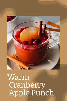 the cover of warm cranberry apple punch, with cinnamon sticks and apples in it