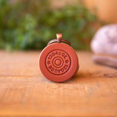 a red leather keychain sitting on top of a wooden table