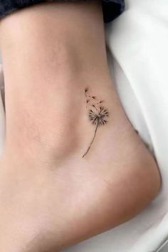 #TattooArt #InkLife #BodyArt #TattooInspiration #InkedUp #TattooLove #TattooedWomen #TattooedMen #InkCommunity #TattooStories Elegant Ankle Tattoos, Dandelion Foot Tattoo, Dandelion Ankle Tattoo, Ankel Tattoos Simple, Minimalist Foot Tattoo, Kindness Tattoo Ideas, Minimalist Ankle Tattoo, Tattoos For Ankle, Dainty Ankle Tattoo