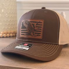 American Flag Eagle patch hat. Specifications: 🧢 Richardson original 112 trucker; adjustable for the perfect fit 🎩 60/40 cotton/polyester blend for comfort 📏 One size fits most 🏷️ Expertly laser engraved leatherette patch design 📦 Ships in 2 to 3 business days from our Orlando Studio Care Instructions: 🚫 Do not wash; spot clean only Please Note: 🌈 Colors may vary from photos based on your viewing screen. This funny hat is a unique and entertaining gift for fathers, embracing their dual ro Orlando Studios, American Flag Eagle, Entertaining Gifts, Funny Hats, Patch Design, Leather Patches, Gifts For Father, American Flag, Laser Engraving