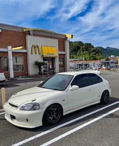 a white car parked in front of a mcdonald's