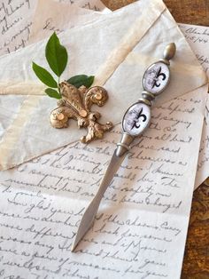 a pair of scissors sitting on top of an old letter with leaves and letters around it