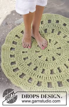 a woman standing on top of a green rug with her bare feet in the middle