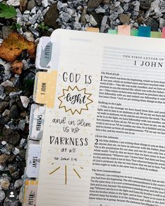 an open bible laying on the ground with rocks and gravel in front of it that says, god is right and we are not darkness at all