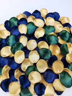 a pile of blue, green and gold satin flower petals