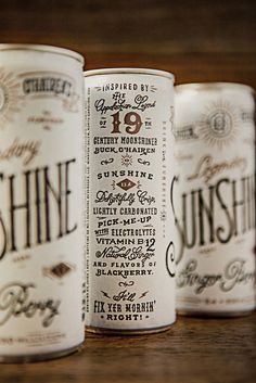 three cans of sunshine beer sitting on top of a wooden table next to each other