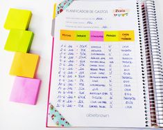 an open notebook with spanish words on it next to colored sticky notes and rubber blocks