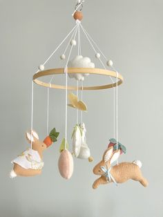 several stuffed animals are hanging from a mobile in the shape of a baby's crib