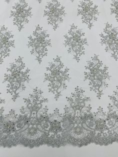 an embroidered white fabric with silver sequins