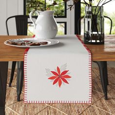 a table topped with a white plate covered in food next to a vase filled with flowers