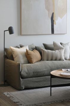 a living room with a couch, coffee table and painting on the wall behind it