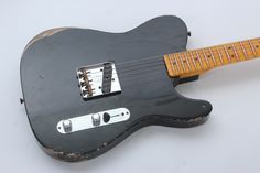 an old black electric guitar sitting on top of a table