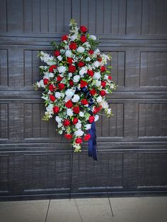 a bunch of flowers that are on the side of a garage door with a blue ribbon