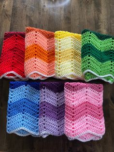 four crocheted dishcloths on a wooden table