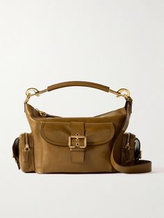 Chloé's 'Camera' bag is a cool re-interpretation of practical vintage styles. Made from leather, it has plenty of outer pockets that create its distinct shape and features polished gold-tone hardware, including buckled straps. Carry it by the detachable top handle or adjustable cross-body strap, and stow your wallet, sunglasses case and a cosmetics pouch inside. Luxury Rectangular Camera Bag With Gold-tone Hardware, Travel Shoulder Camera Bag With Gold-tone Hardware, Travel Camera Shoulder Bag With Gold-tone Hardware, Leather Camera Shoulder Bag With Gold-tone Hardware, Designer Leather Camera Bag With Detachable Strap, Chic Leather Camera Bag With Gold-tone Hardware, Rectangular Leather Camera Bag With Gold-tone Hardware, Luxury Camera Bag With Gold-tone Hardware For Everyday Use, Boot Pumps