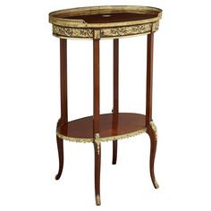 an oval wooden table with gold trimmings on the top and bottom, sitting against a white background