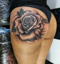 a woman's thigh with a rose tattoo on it