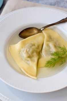 a white plate topped with dumplings covered in sauce