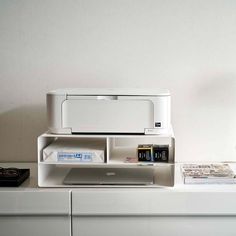 a printer sitting on top of a white shelf