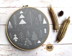 a cross stitch pattern on a gray and gold hoop