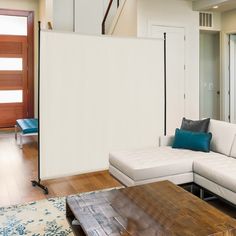 a living room filled with furniture and a large white screen in the middle of it