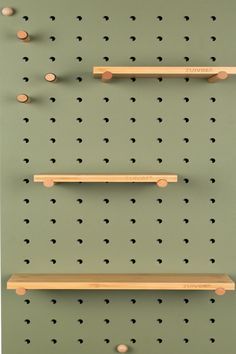 three wooden shelves with pegs on them