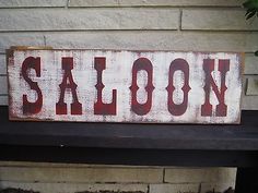 a wooden sign that says saloon on it