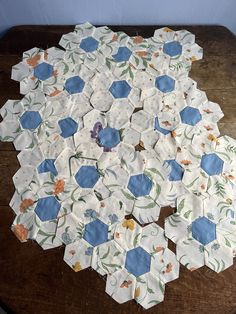 a wooden table topped with lots of white and blue hexagonals on top of each other