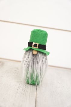 a green and white gnome's hat on top of a wooden table