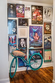 a blue bike parked in front of a wall with posters on it