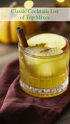 a close up of a drink in a glass with an apple and cinnamon stick on top