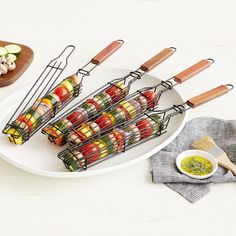 several skewers are arranged on a plate with dipping sauces next to them