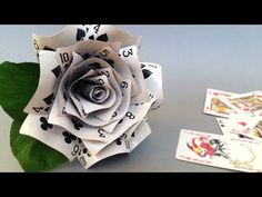 an origami rose and playing cards on a table