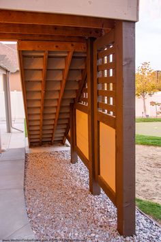 the entrance to an apartment building with wood slats on it's sides and stone walkway