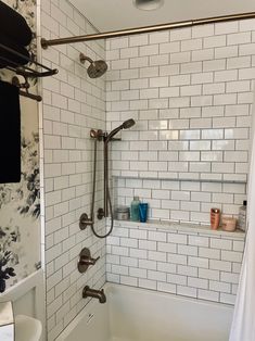 a bathroom with white tile and black and white tiling on the shower head, tub, and shelves