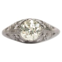 an antique style diamond ring with filigrees on the band and center stone