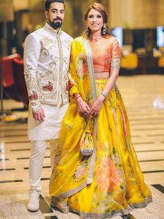 a man and woman standing next to each other in formal wear, posing for the camera