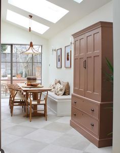 a room with a table, chairs and a cabinet in it that is open to the outside