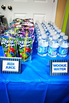 a table topped with lots of bottles of water and candy bar wrappers on top of it